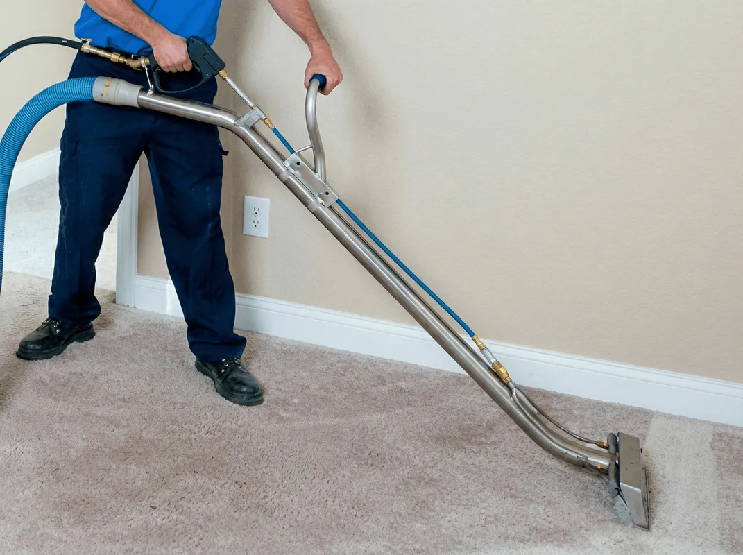 Professional operating a liquid removal machine on a carpeted floor in Portland, OR
